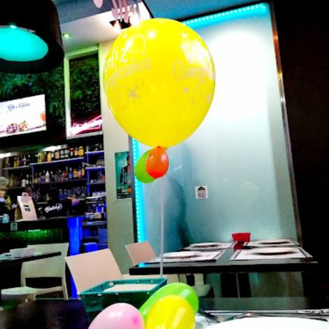 mesa de restaurante adornada con globos y carteles